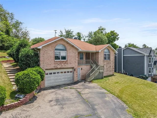 a view of a house with a yard and potted plants