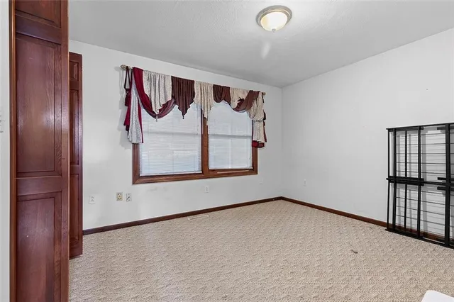 an empty room with windows and cabinet
