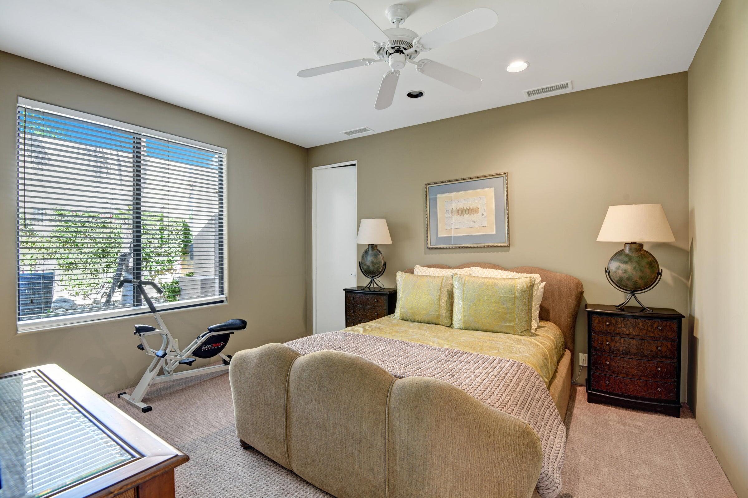 50445 Mountain Shadows Road La Quinta, CA 92253 - Photo 30 of 33 a bedroom with a bed and a chandelier