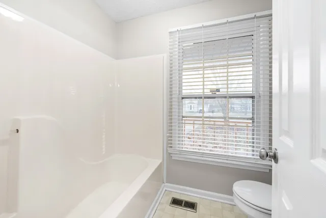 a view of a hallway with wooden floor and a shower