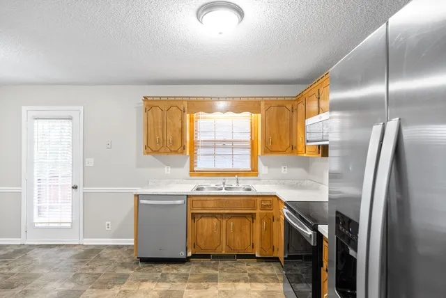 a kitchen with stainless steel appliances granite countertop a sink stove and refrigerator
