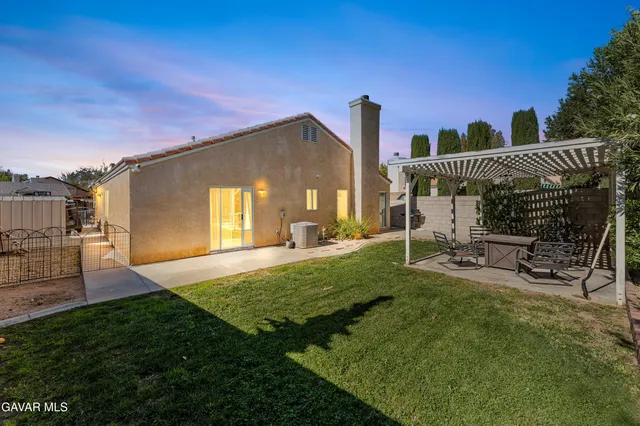 a view of a chair and table in backyard of the house