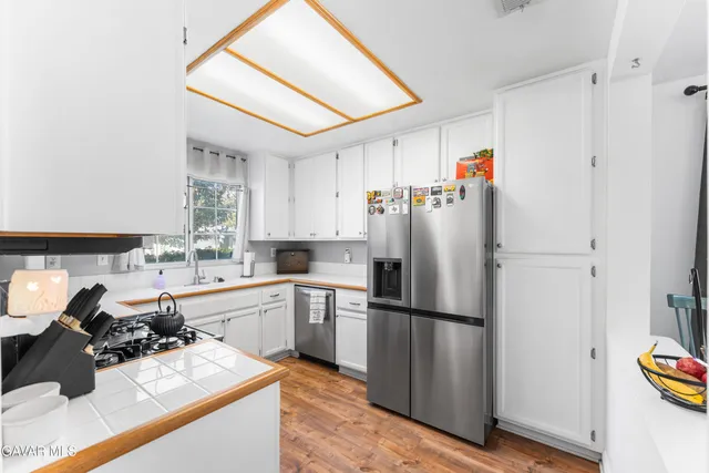 a kitchen with a sink a refrigerator and a stove top oven