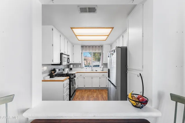 a kitchen with stainless steel appliances granite countertop a refrigerator and a stove