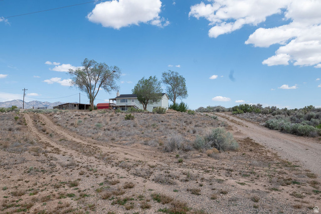 570 West Main Street Beaver, UT 84713 - Photo 43 of 43 Expansive desert landscape with a single-family residence featuring a raised foundation, a broad balcony, and a white exterior