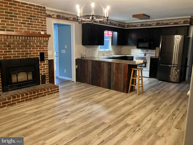 a kitchen with stainless steel appliances granite countertop a refrigerator and a stove top oven
