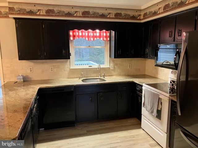 a kitchen with a sink and a stove top oven