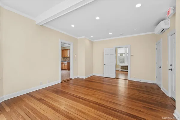 a view of an empty room with wooden floor and closet