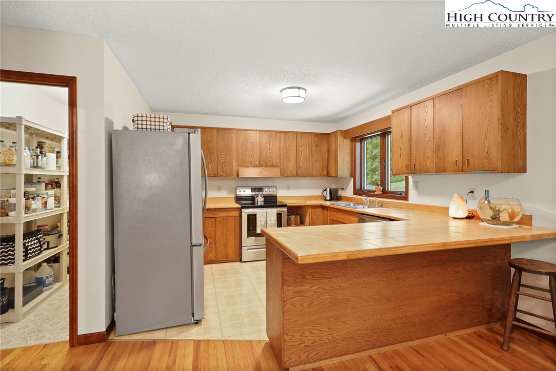 393 Trillium Ridge Boone, NC 28607 - Photo 16 of 50 a kitchen with stainless steel appliances granite countertop a refrigerator a sink and a stove