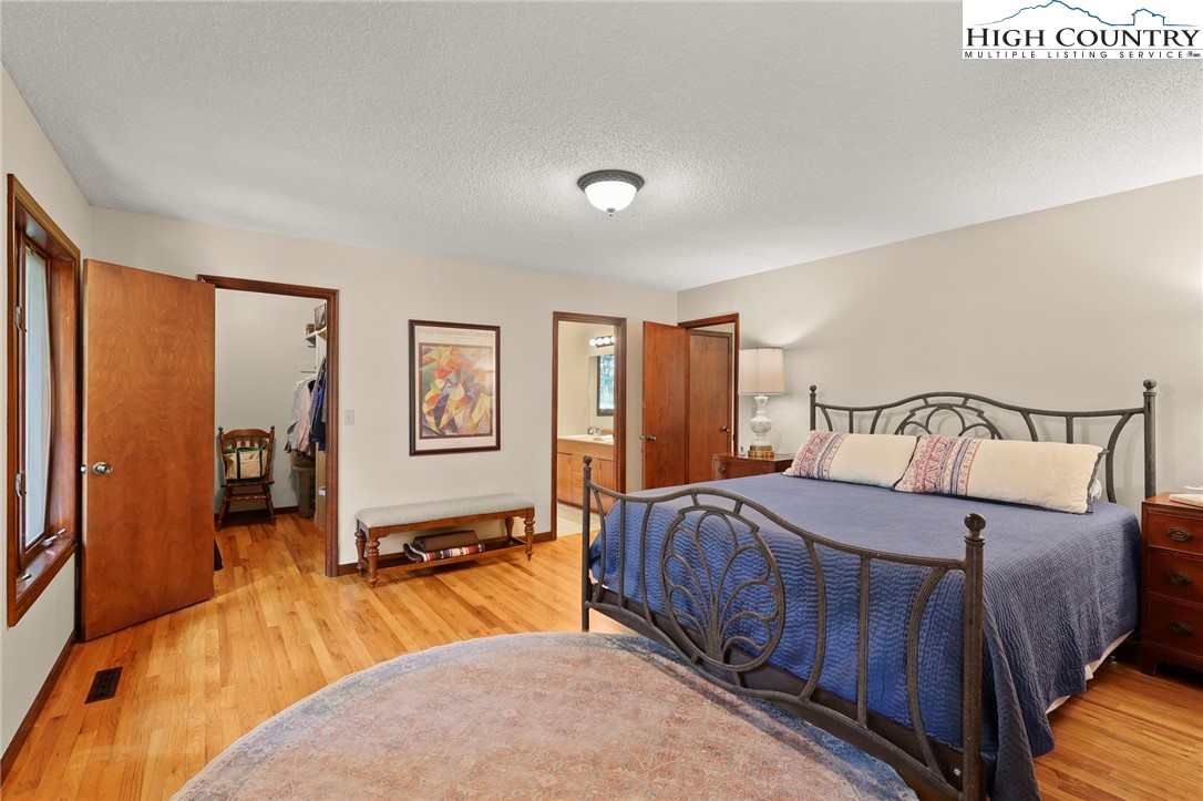393 Trillium Ridge Boone, NC 28607 - Photo 24 of 50 a bedroom with a large bed and a chandelier