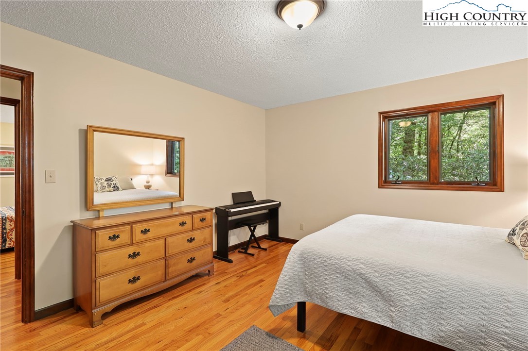 393 Trillium Ridge Boone, NC 28607 - Photo 29 of 50 a bedroom with a bed and wooden floor