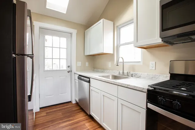 a kitchen with a sink stove top oven and cabinets