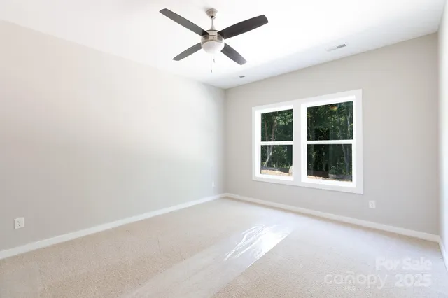 an empty room with a window and a ceiling fan
