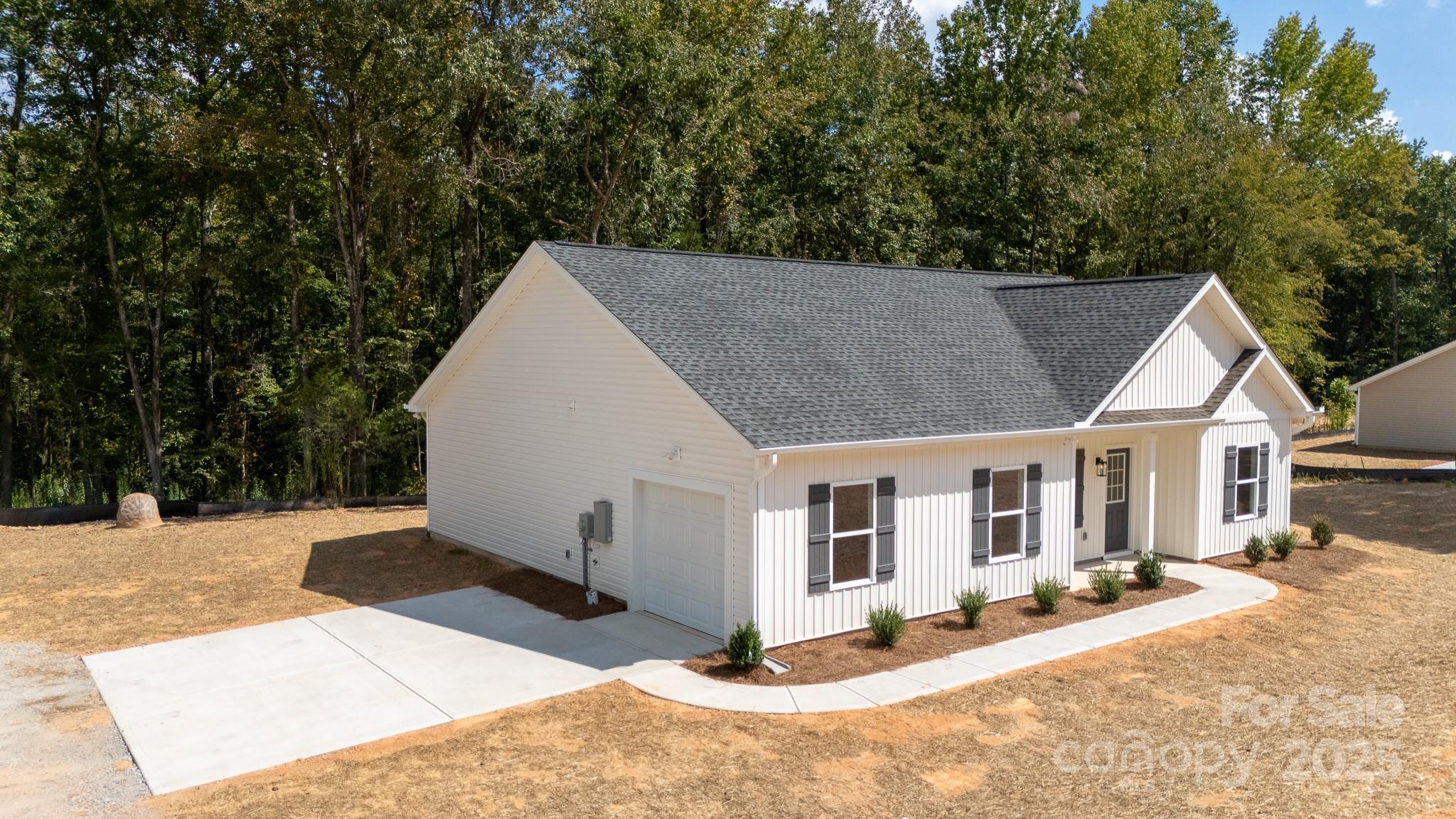3339 Lesslie Highway, Unit 2 Rock Hill, SC 29730 - Photo 6 of 42 a view of a white house with a yard outdoor seating and covered with trees