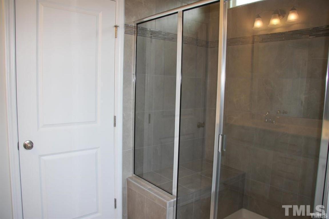 2919 Sunflower Road Apex, NC 27502 - Photo 22 of 34 a bathroom with a glass shower door