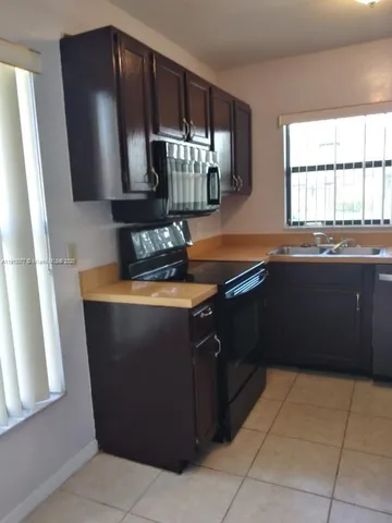 a kitchen with stainless steel appliances granite countertop a sink and a microwave