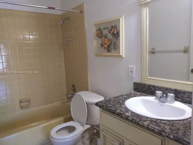 a bathroom with a granite countertop sink mirror toilet and bathtub