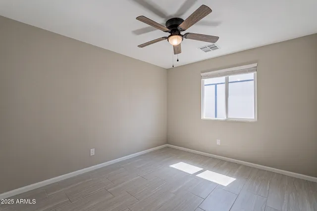 an empty room with a window and a fan