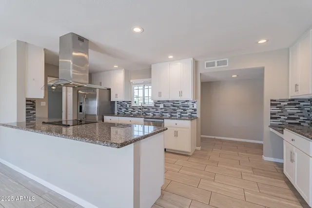 a kitchen with stainless steel appliances granite countertop a sink and a stove