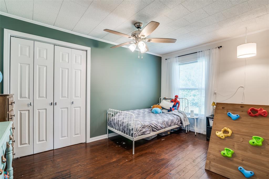 113 Caddo Street Josephine, TX 75173 - Photo 15 of 31 a bedroom with a bed and wooden floor
