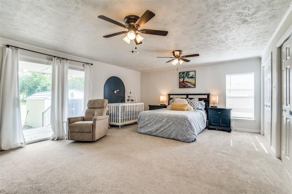 113 Caddo Street Josephine, TX 75173 - Photo 17 of 31 a bedroom with a large bed and ceiling fan