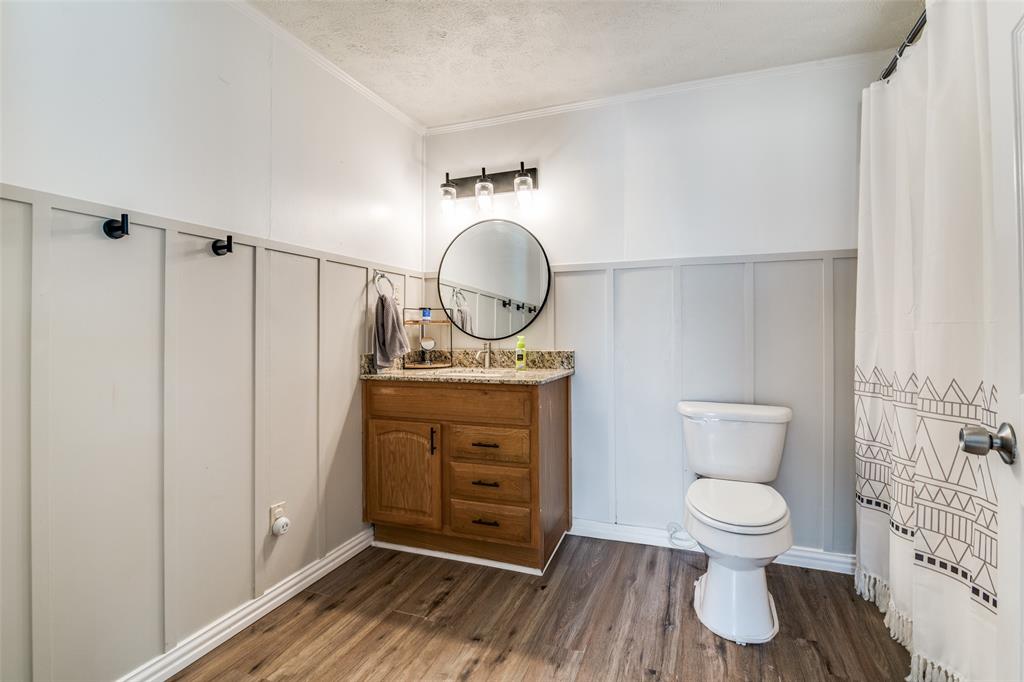 113 Caddo Street Josephine, TX 75173 - Photo 20 of 31 a bathroom with a toilet a sink and a mirror