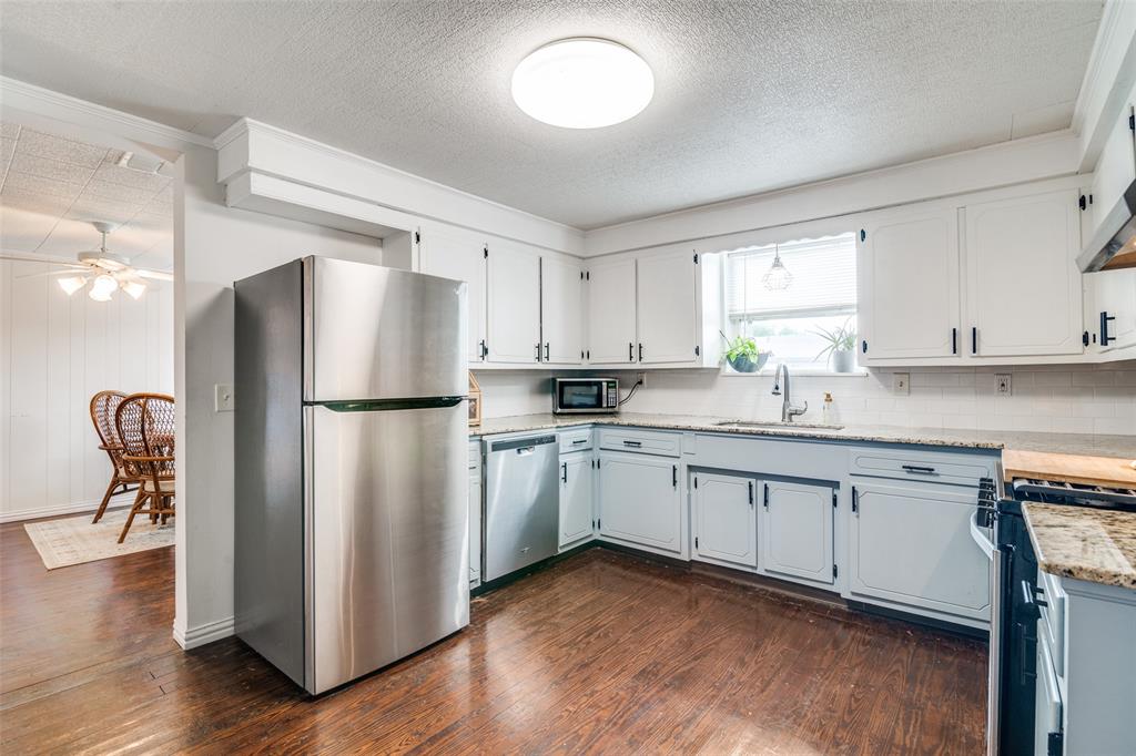 113 Caddo Street Josephine, TX 75173 - Photo 7 of 31 a kitchen with stainless steel appliances granite countertop a refrigerator a sink a stove a dining table and chairs