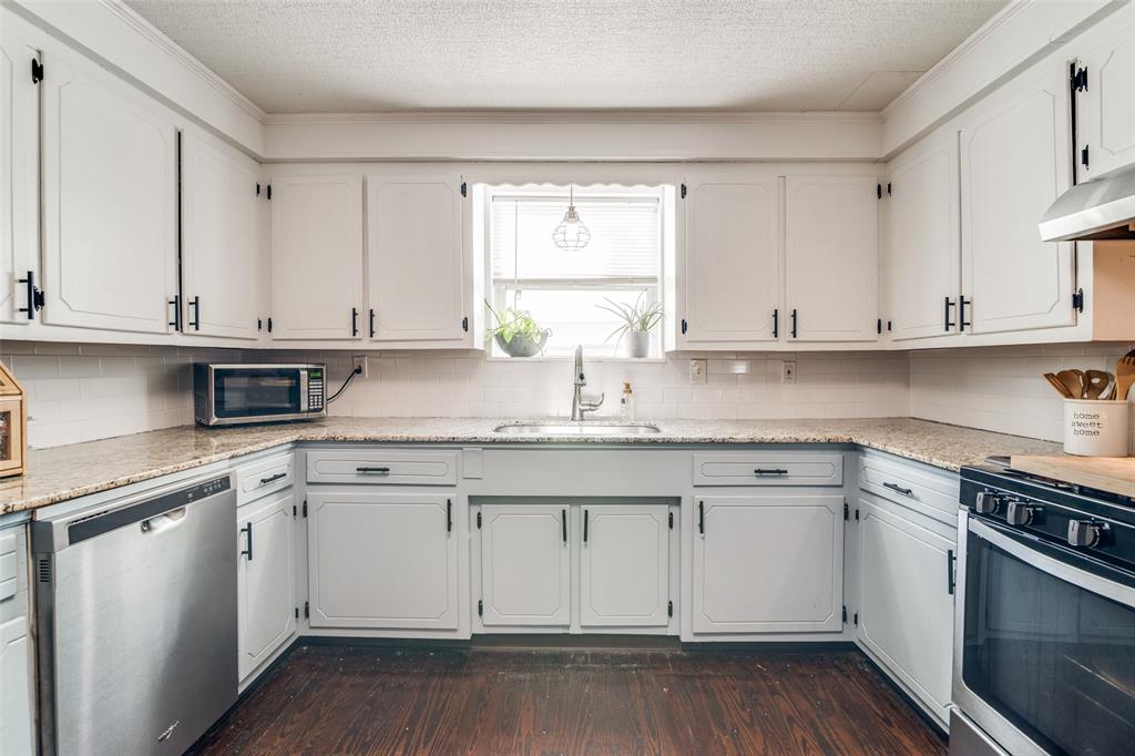 113 Caddo Street Josephine, TX 75173 - Photo 8 of 31 a kitchen with granite countertop white cabinets and a sink