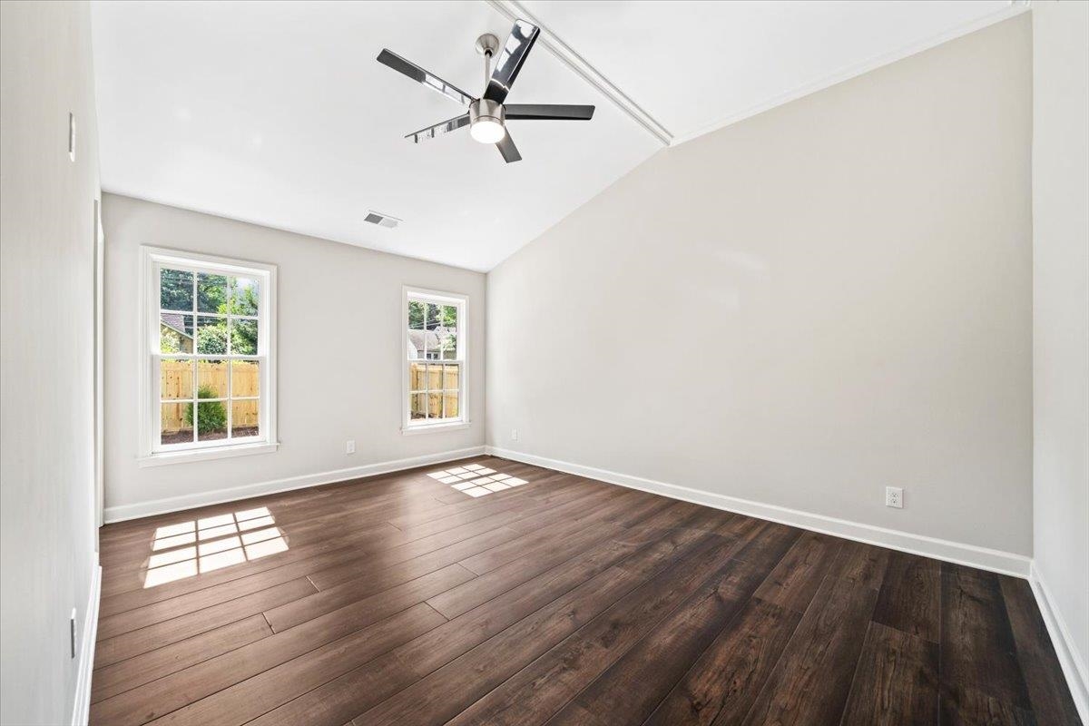 170 South Greer Street Memphis, TN 38111 - Photo 4 of 35 Spacious room featuring vaulted ceilings, two double-hung windows, wood-finish flooring, and a modern ceiling fan with lighting