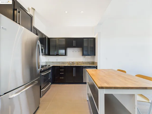 a kitchen with stainless steel appliances a sink and a refrigerator
