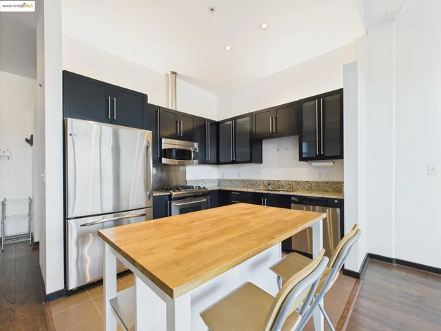 a kitchen with stainless steel appliances granite countertop a refrigerator and a stove top oven