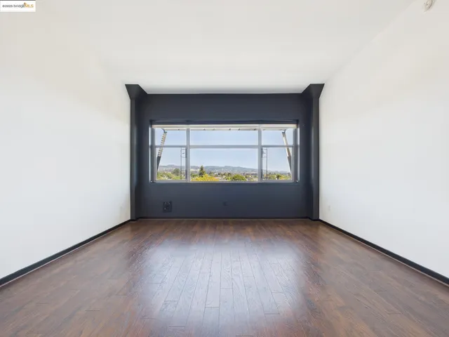 a view of a room with wooden floor and a window