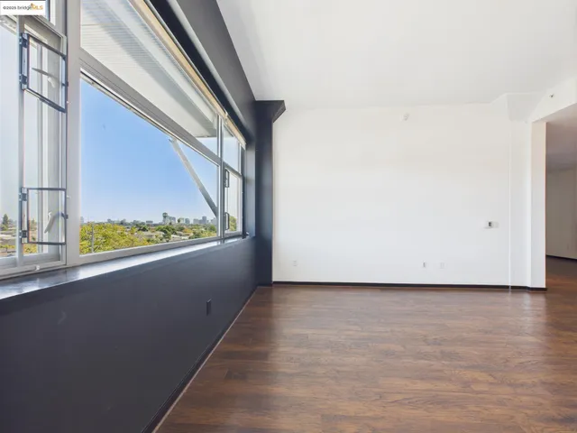 a view of a room with wooden floor and a window