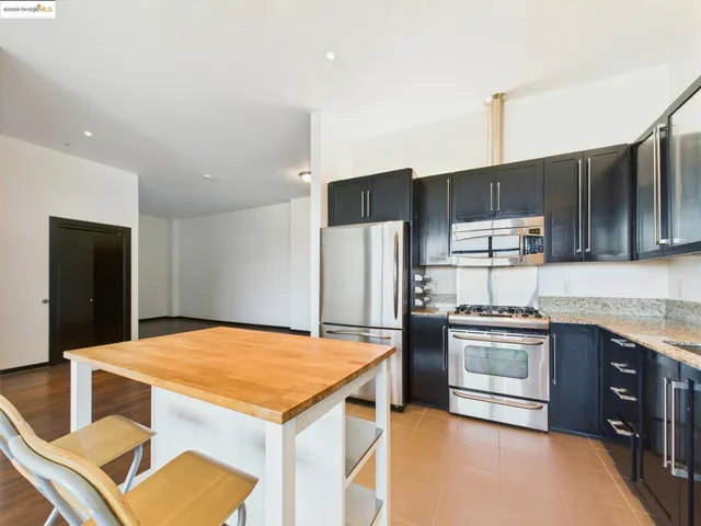 a kitchen with stainless steel appliances kitchen island a stove a sink and a refrigerator