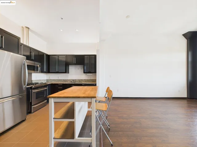 a kitchen with stainless steel appliances granite countertop a refrigerator and a stove