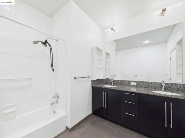 a bathroom with a granite countertop sink mirror and a bathtub
