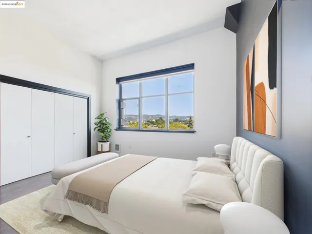 a bedroom with a bed mirror and window