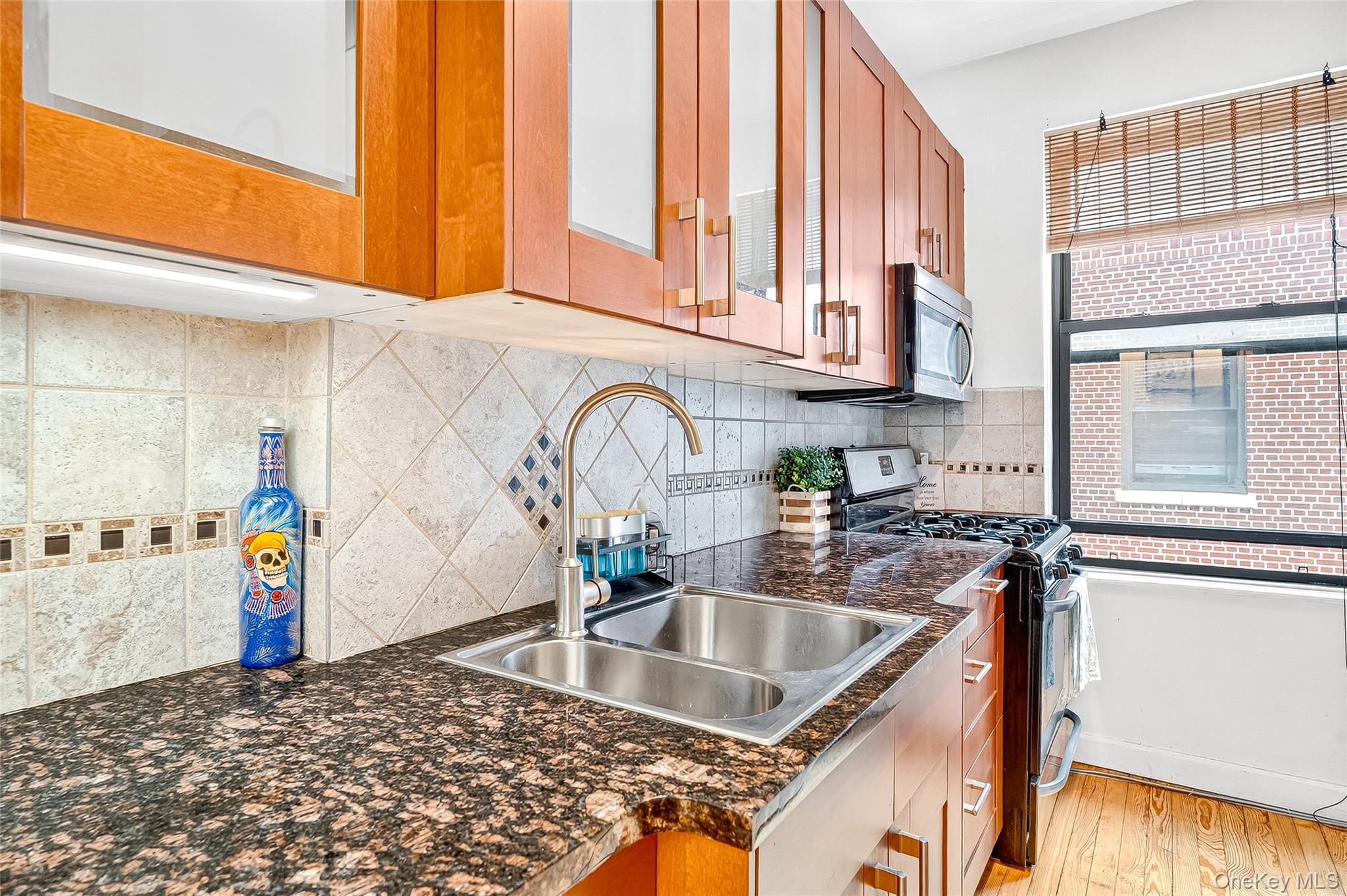 1976 Lafontaine Avenue, Unit 4D Bronx, NY 10457 - Photo 12 of 32 a kitchen with stainless steel appliances granite countertop a sink and a wooden cabinets