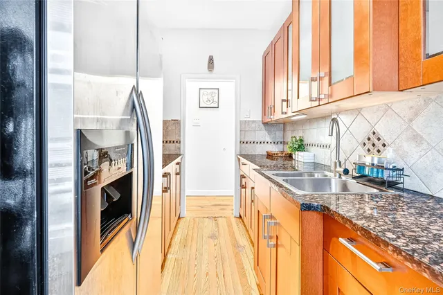 a kitchen with stainless steel appliances granite countertop a sink a stove and a refrigerator
