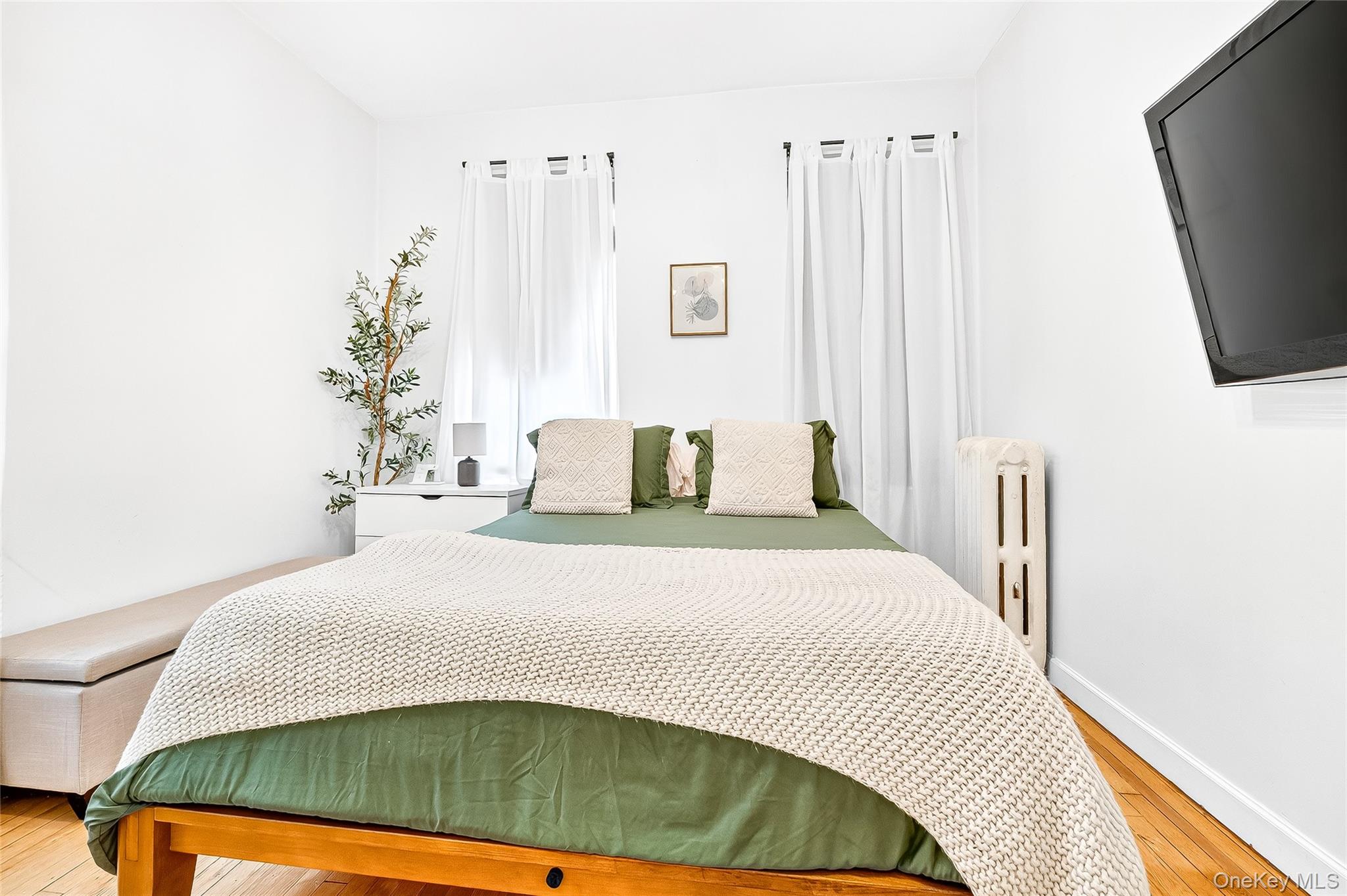 1976 Lafontaine Avenue, Unit 4D Bronx, NY 10457 - Photo 27 of 32 a bedroom with a bed and a flat screen tv