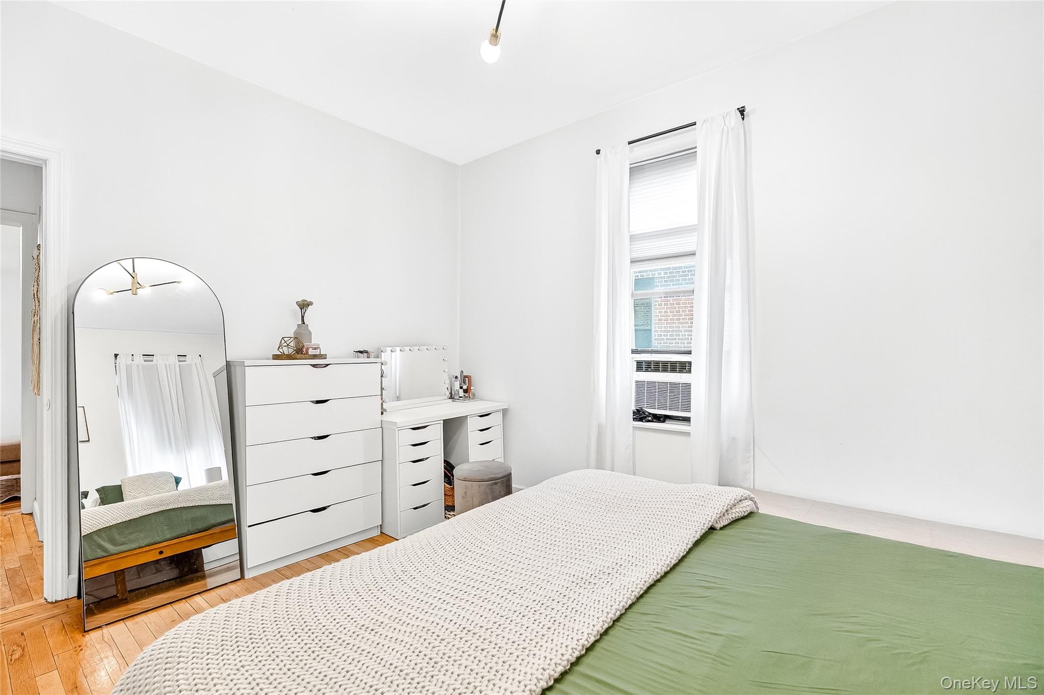 1976 Lafontaine Avenue, Unit 4D Bronx, NY 10457 - Photo 30 of 32 a bedroom with a bed and a mirror