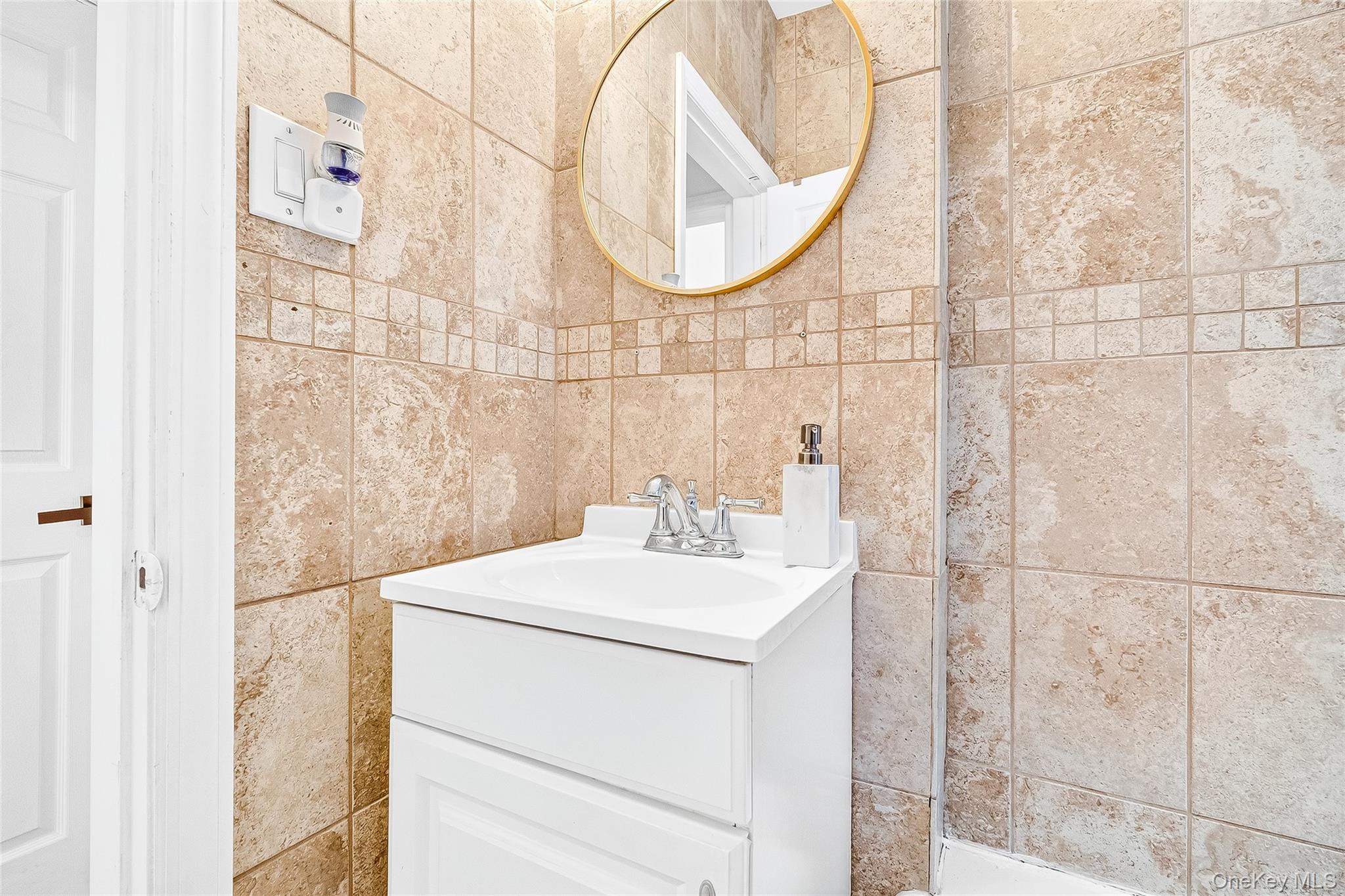 1976 Lafontaine Avenue, Unit 4D Bronx, NY 10457 - Photo 32 of 32 a bathroom with a sink and a mirror