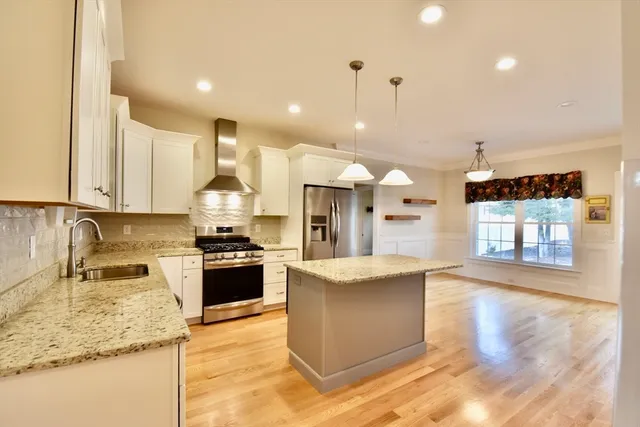 a view of kitchen with stainless steel appliances granite countertop a refrigerator and a stove top oven