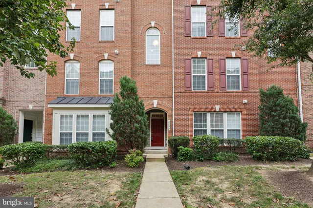 front view of a brick house with a yard