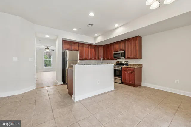 a kitchen with stainless steel appliances a refrigerator a stove a microwave and a sink