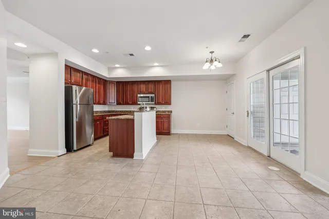 a kitchen with stainless steel appliances granite countertop a stove top oven a sink and a refrigerator
