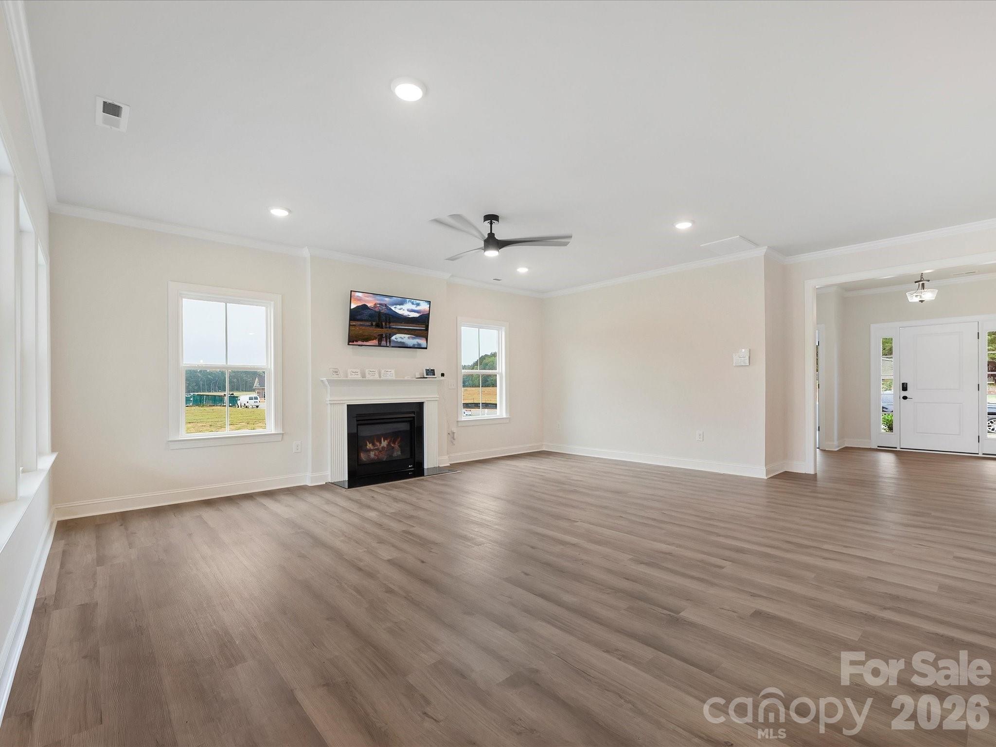 1296 Archer Loop Monroe, NC 28110 - Photo 15 of 39 wooden floor fireplace and windows in an empty room
