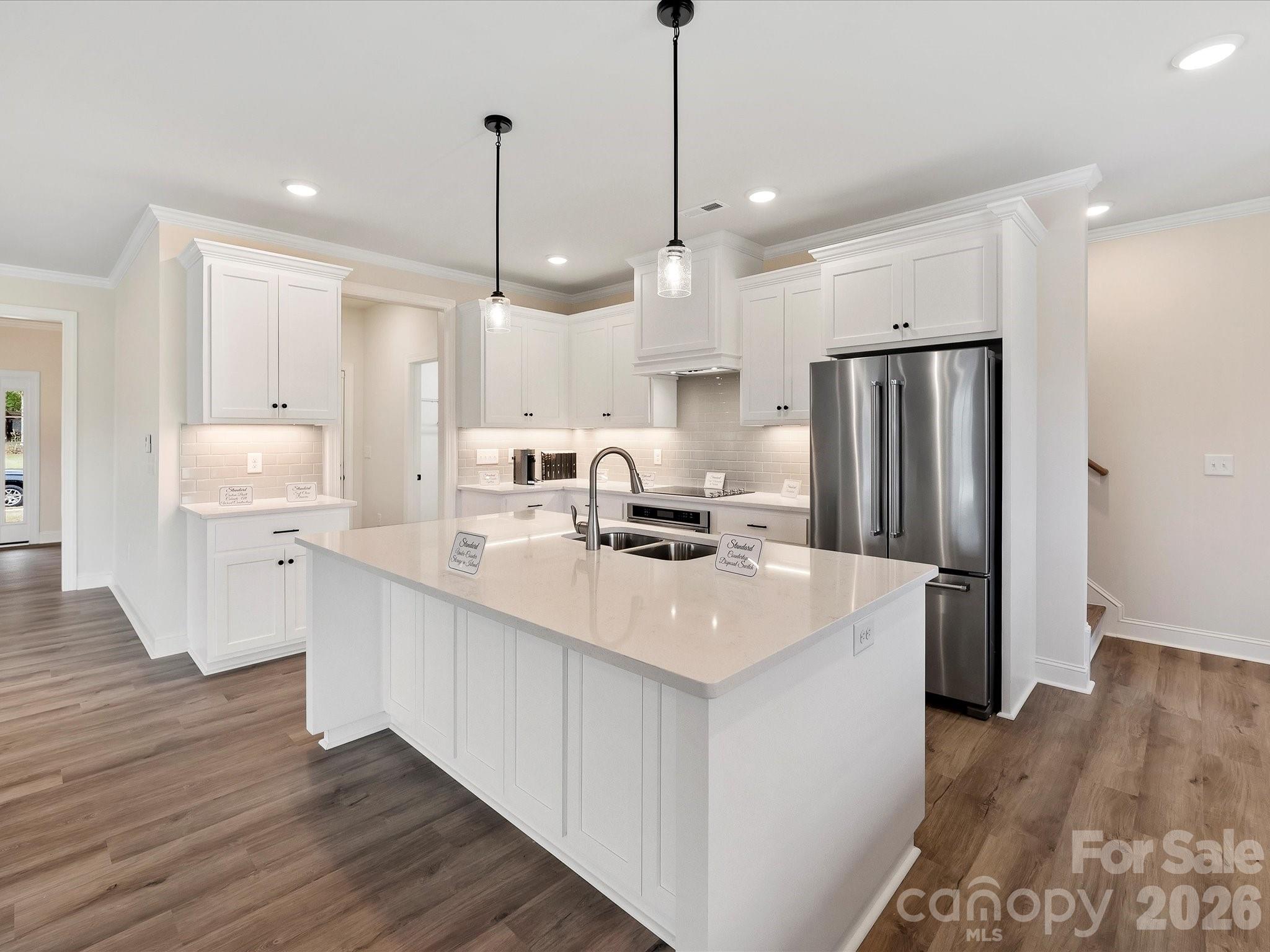 1296 Archer Loop Monroe, NC 28110 - Photo 8 of 39 a kitchen with stainless steel appliances a refrigerator a sink dishwasher a stove and white cabinets with wooden floor