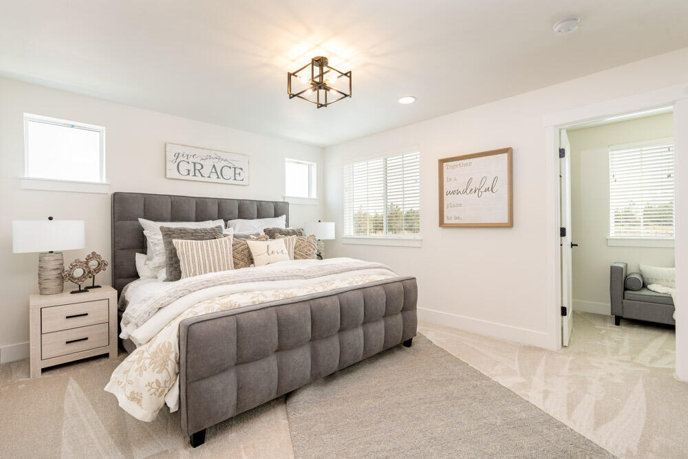 3749 Eagle Road Bend, OR 97701 - Photo 4 of 28 a spacious bedroom with a bed a couch and a window