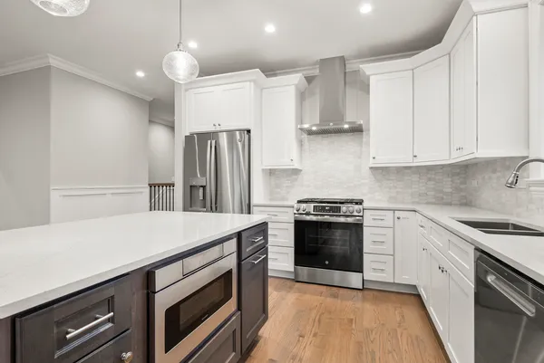 a kitchen with stainless steel appliances a stove a sink and a refrigerator